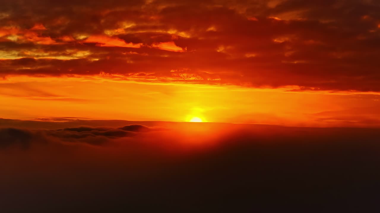Filmreifer Sonnenaufgang mit von Wolkenschichten teilweise verdeckter Sonne.
