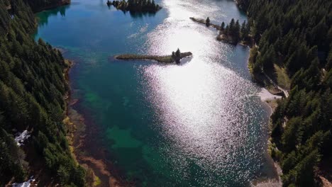 beautiful shot flying over gold creek pond surrounded by evergreen forest in washington state