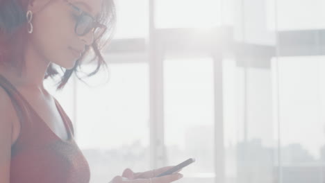 mujer usando un teléfono inteligente en una oficina moderna
