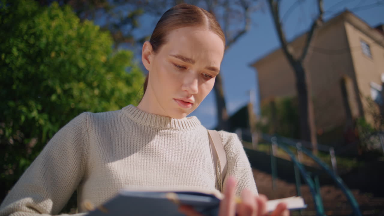 Attractive girl checking schedule sunlight park closeup. Student flipping book