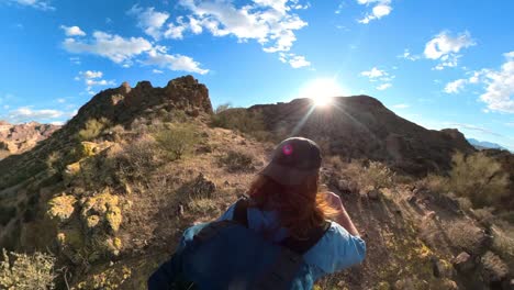 las bengalas del sol estallan sobre las crestas de los excursionistas pelirrojos una colina en un desierto de montaña rocosa