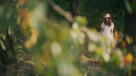 dreamy girl with flowers walking in tree alley