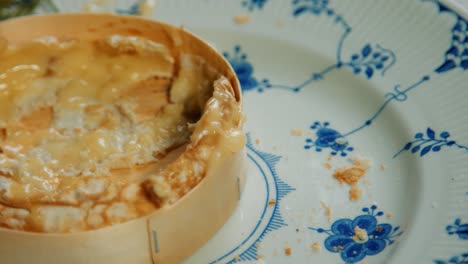 pan over hand dipping baguette in finished french camembert rind