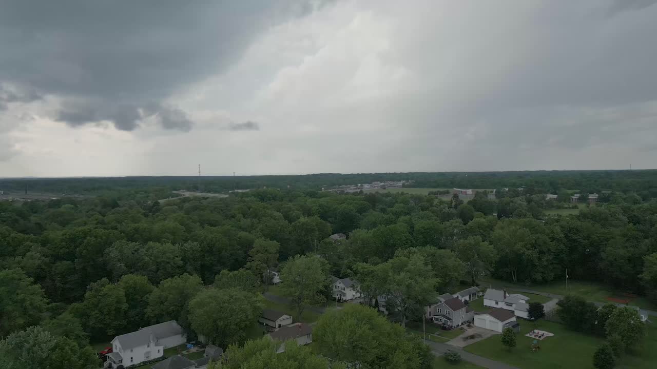 vista aérea de un vecindario suburbano enclavado contra un vasto bosque verde
