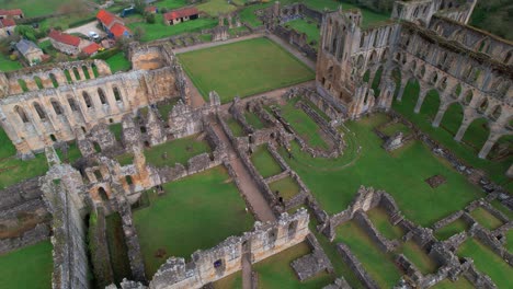 tourists on historical ruins of rievaulx abbey near helmsley in the north york moors national park, north yorkshire, england