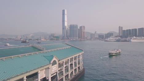 hong kong star ferry, central terminal and harbour front. aerial drone view