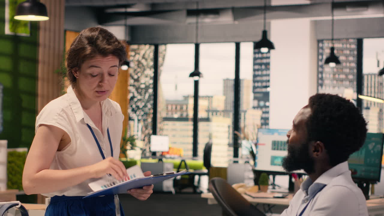Diverse employees reviewing data analysis and reporting in office