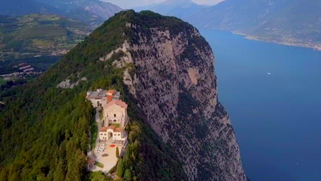 aerial view of a church on a cliffside overlooking a lake in italy