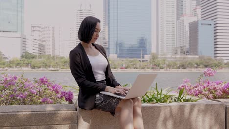 businesswoman working on laptop outdoors