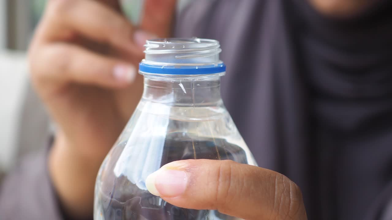 Hands holding a water bottle