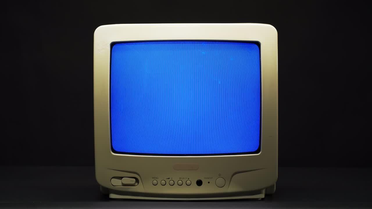 Old retro square television with blue screen on black background. Old-fashioned TV with bad signal reception, tv setting concept, ripples and interference, searching channel