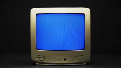 vieja televisión cuadrada retro con pantalla azul sobre fondo negro. televisión anticuada con mala recepción de señal, concepto de ajuste de televisión, ondas e interferencias, búsqueda de canal