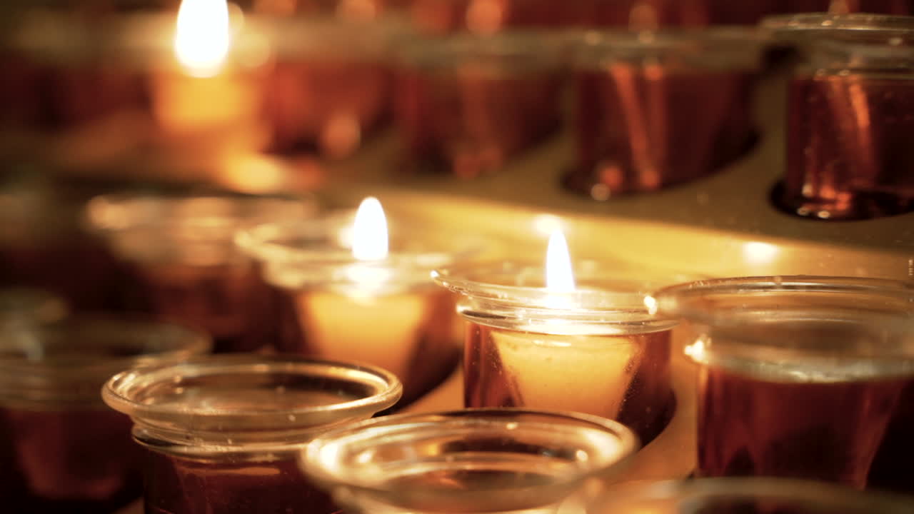 velas de oración encendidas en una iglesia tranquila y oscura