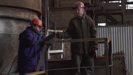 factory workers inspecting machinery