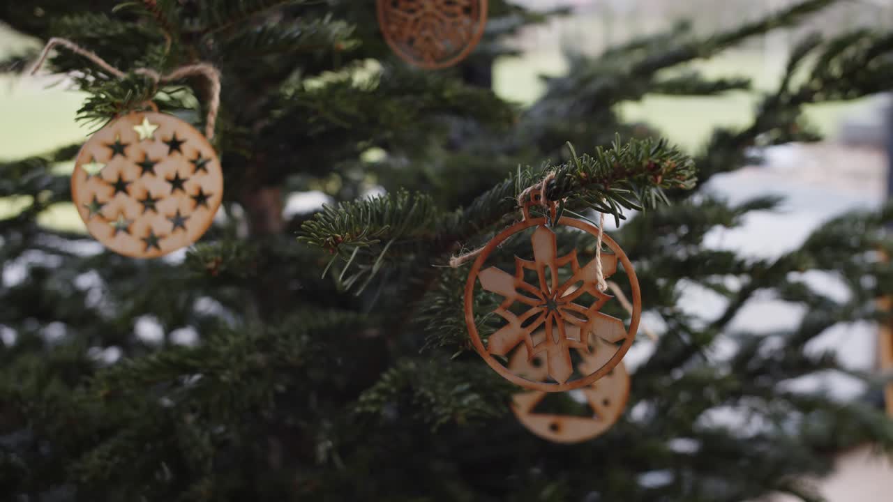 colgar la decoración tradicional de navidad de madera mínima en el árbol