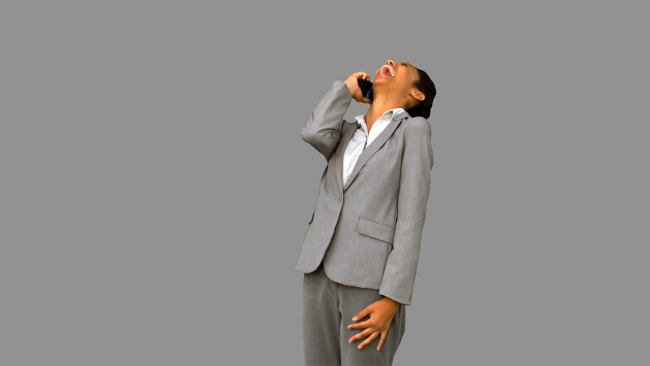 회색 스크린에서 전화를 할 때 웃는 행복한 사업가