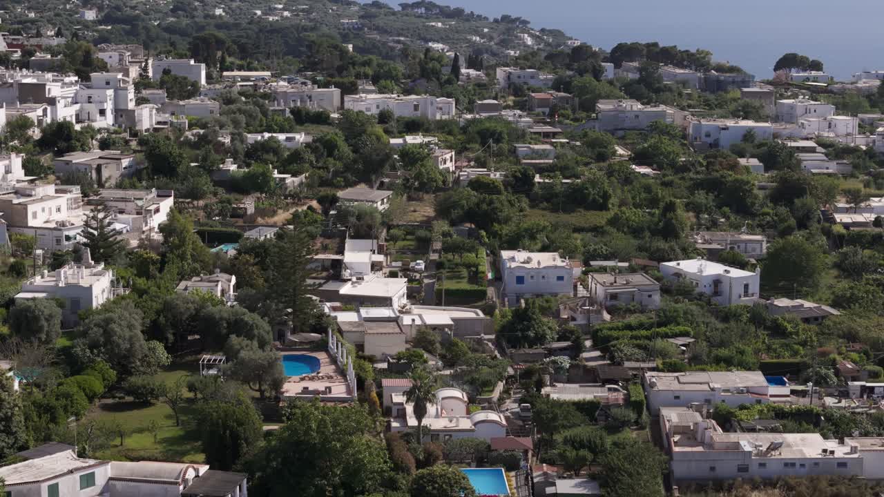 Orbital drone shot panning right, capturing a close-up view of the white houses in Anacapri, Capri Island