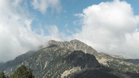 timelapse of white clouds moving over the rocky peak of pyrenees mountain near andorra in spain