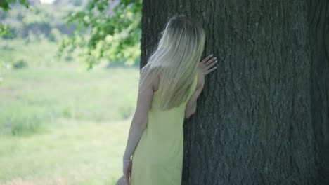 Happy beautiful young girl dancing of freedom in summer park with trees in the background.