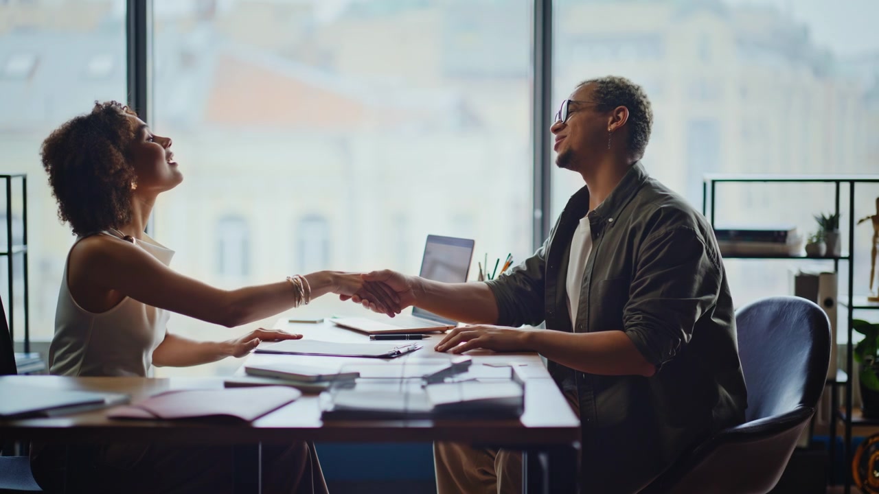 Homme et femme signant un contrat lors d'une réunion de bureau. Poignée de main professionnelle pour un accord réussi