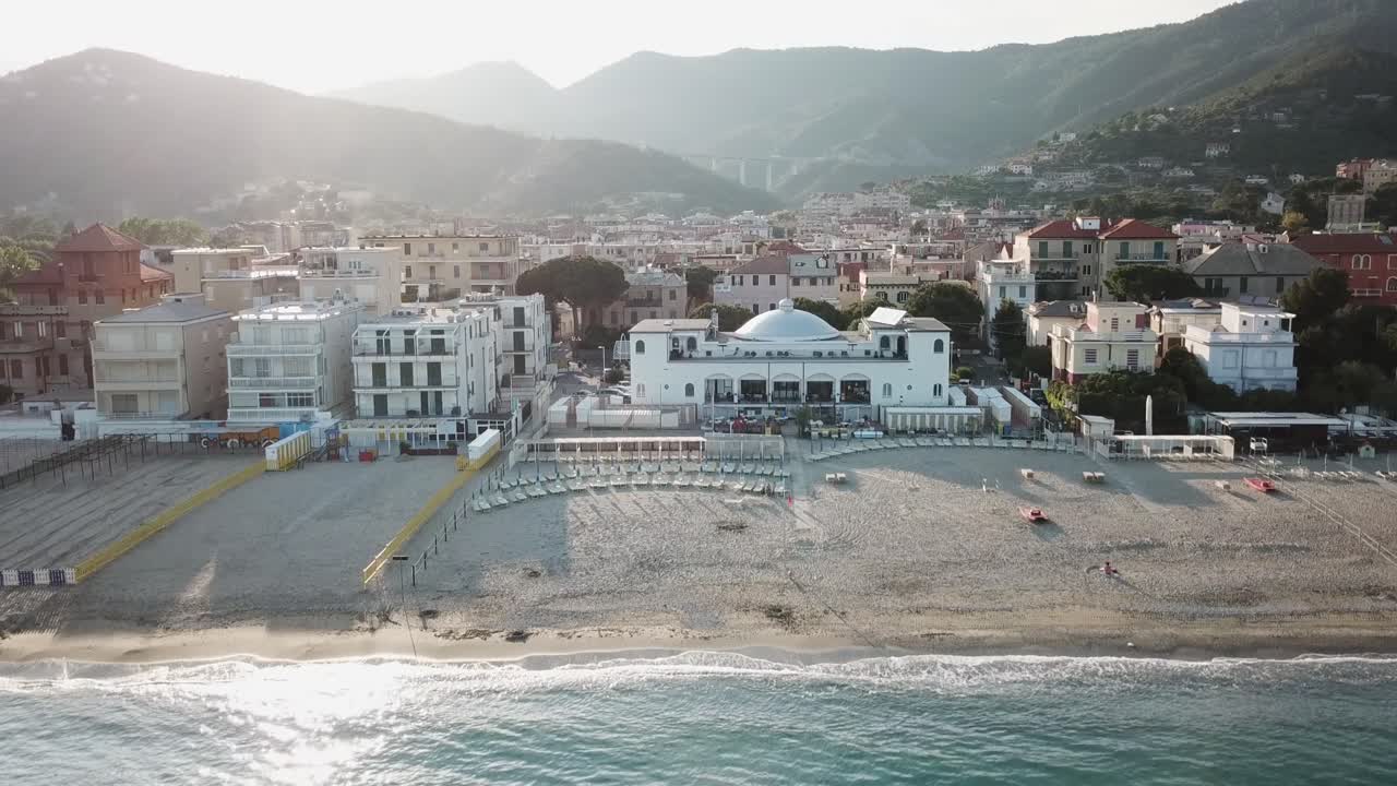 Aerial shot of a village next to the Mediterranean sea, sunset, Italy