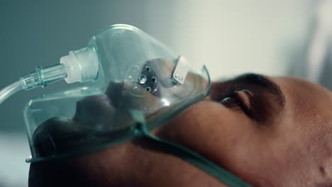 patient face breathing oxygen mask closeup. infected man wear respirator in ward