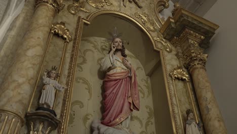 grand, gilded church altar displays sacred statues, including jesus christ