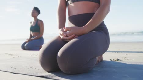 Group-of-diverse-female-friends-meditating-at-the-beach
