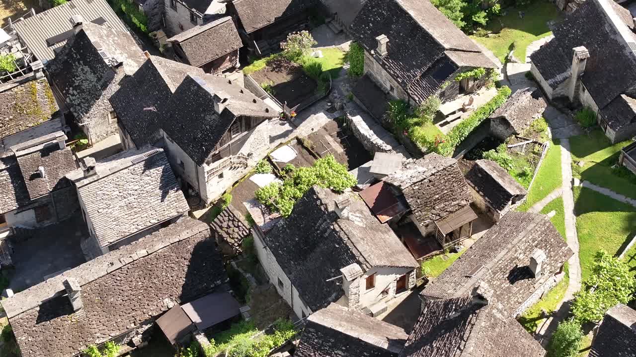 Stone houses with slate roofs nestled in greenery near a waterfall, traditional architecture of Maggiatal Vallemaggia, Switzerland