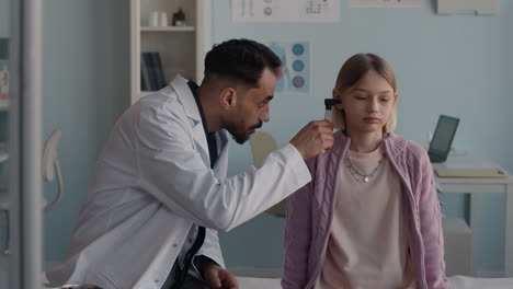 doctor examining a child's ear with an otoscope