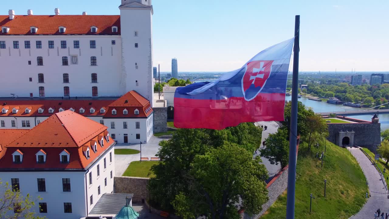 슬로바키아 국기가 바람에 흔들리고 브라티슬라바 성이 배경입니다.