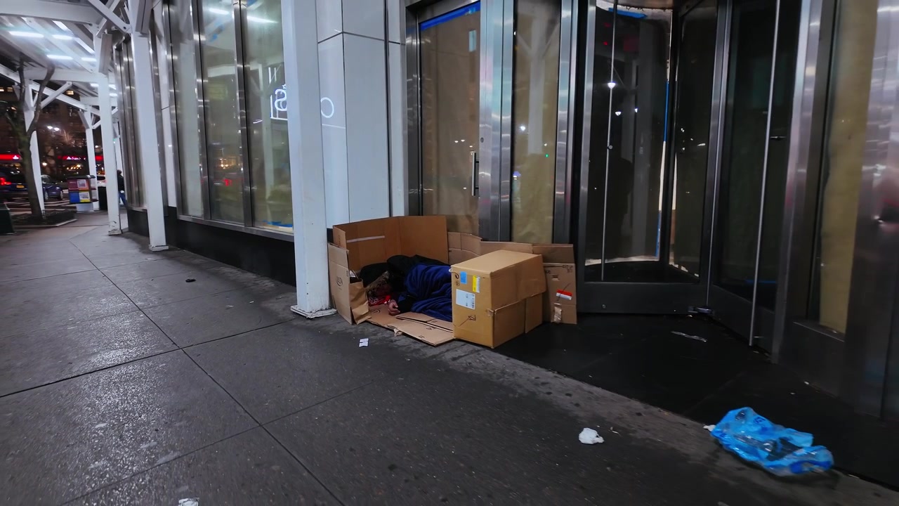 Nueva York, EE. UU., 24 de agosto de 2025: Persona sin hogar durmiendo en la acera de Nueva York. Persona sin hogar descansando en cajas de cartón en una acera fría de noche en la ciudad de Nueva York.