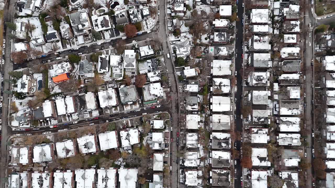 Vista aérea de un barrio urbano nevado con edificios residenciales y calles concurridas, mostrando la infraestructura y el desarrollo de la ciudad, Montreal, Canadá.