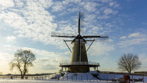 lapso de tiempo de las nubes que pasan sobre el molino de viento tradicional en el hermoso paisaje rural de invierno blanco - pan de derecha a izquierda