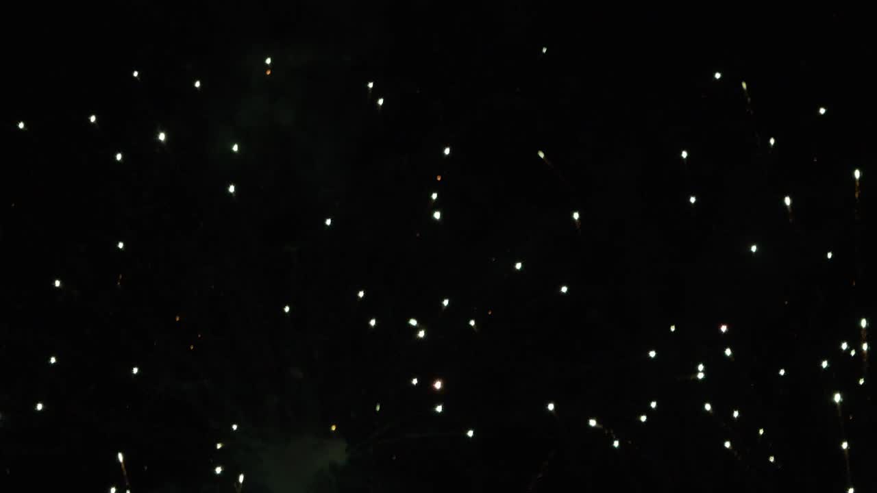 Grande esplosione di fuochi d'artificio con scintille fluttuanti su sfondo nero di notte, design grafico.