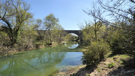 puente de piedra con un arco sobre un río francia herault occitania