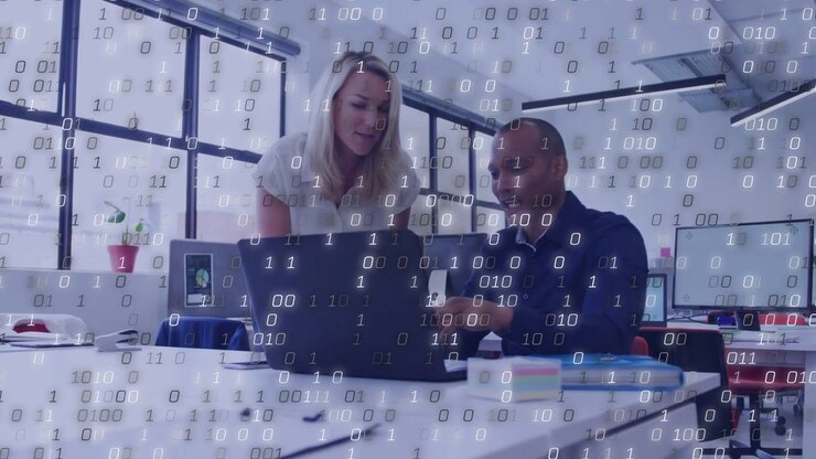 Kvinde bevæger sig mod bærbar computer, mens mand peger, binært overlay intensiveres, driver teknisk gennemgang