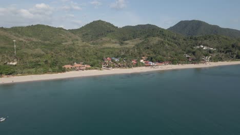 cacerolas aéreas justo sobre el agua, revelando una larga playa de arena en koh lanta
