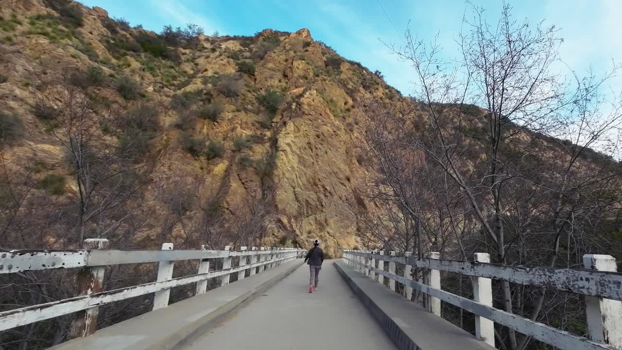 여성은 다리 위 하이킹에 가죽 끈에 개를 산책