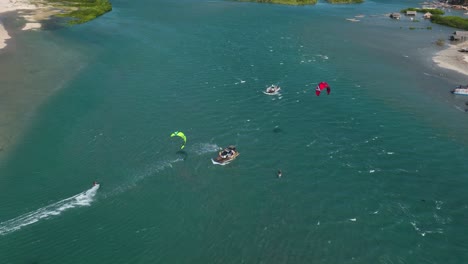 Freestyle-kitesurfing-with-kiters-jumping-over-local-boat---Brazil-coast,-aerial