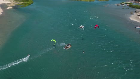 freestyle kitesurfing with kiters jumping over local boat - brazil coast, aerial