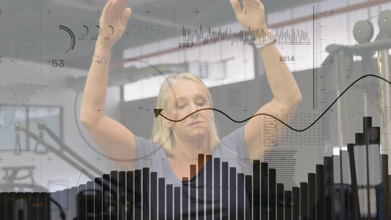 Senior woman raising arms in gym, leaning on bars and pressing while data gauges tracking strength