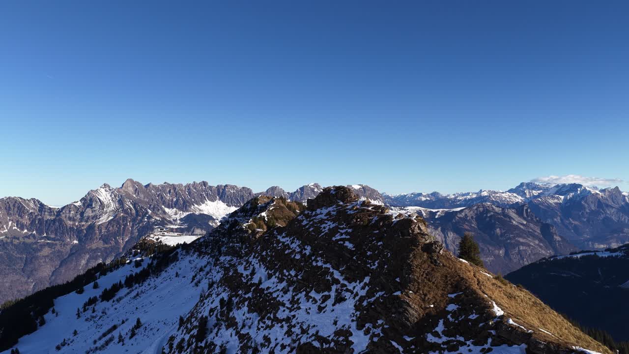 Walensee İsviçre yakınlarındaki Churfirsten sıradağları. Drone ile karlı alp sırtının üzerinde yavaşça ilerlerken, masmavi gökyüzü, çarpıcı zirveler, seyahat, doğa ve kış manzarası
