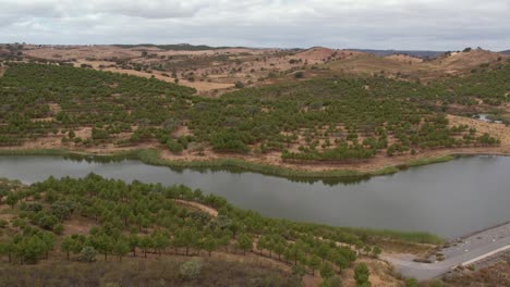 aerial orbiting over water reservoir in rural landscape, lagoon in alentejo