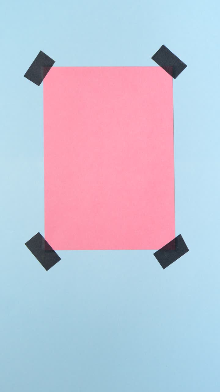 Nota di carta rosa attaccata su sfondo blu chiaro, stop motion in loop con spazio per il testo