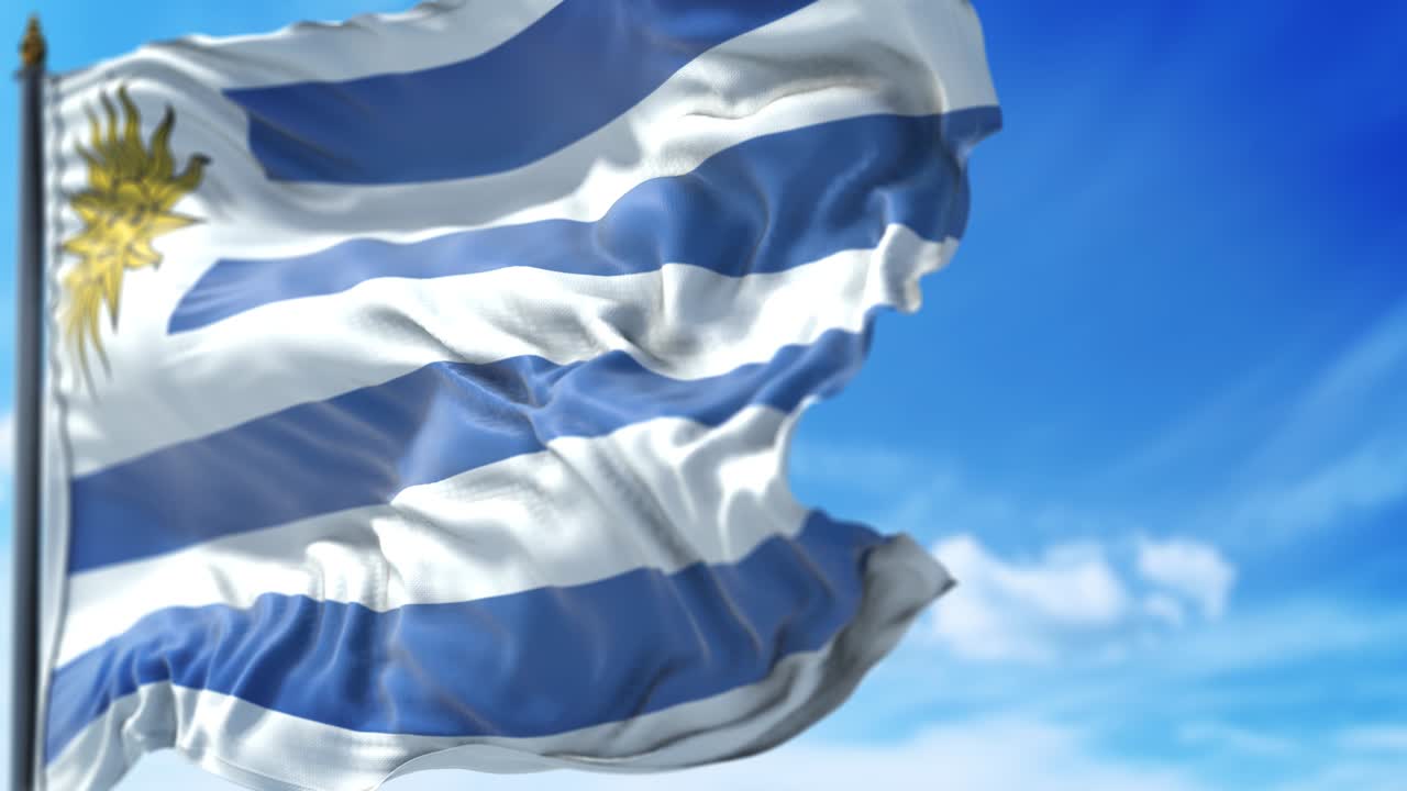 우루과이 국기가 푸른 하늘을 향해 천천히 흔들리고 있습니다.