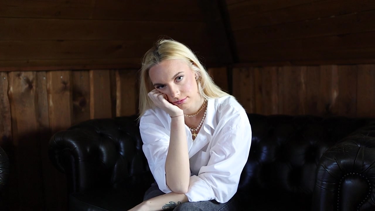 Primo piano al rallentatore di una bella donna bionda, malinconica e pensierosa, seduta da sola.