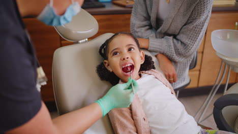 dentist examining little girl's mouth