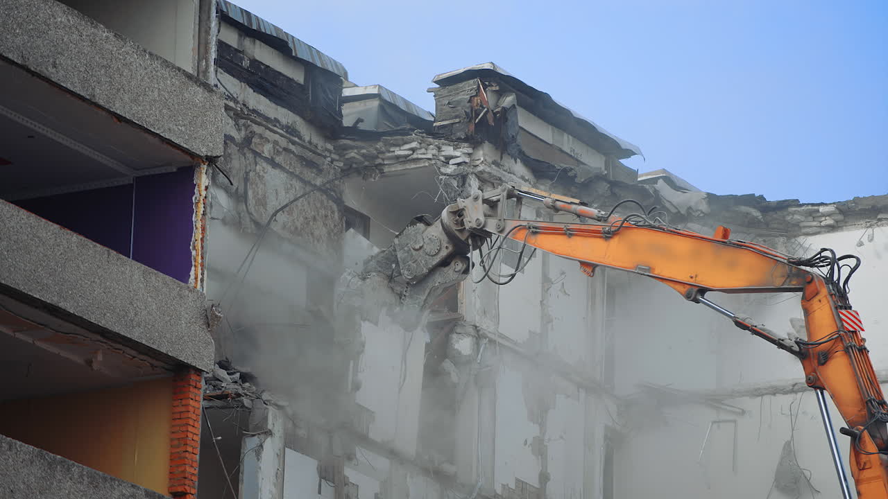 Demolition Of Old Residential Building. Destroying Old House Using Bucket Excavator on Construction Site