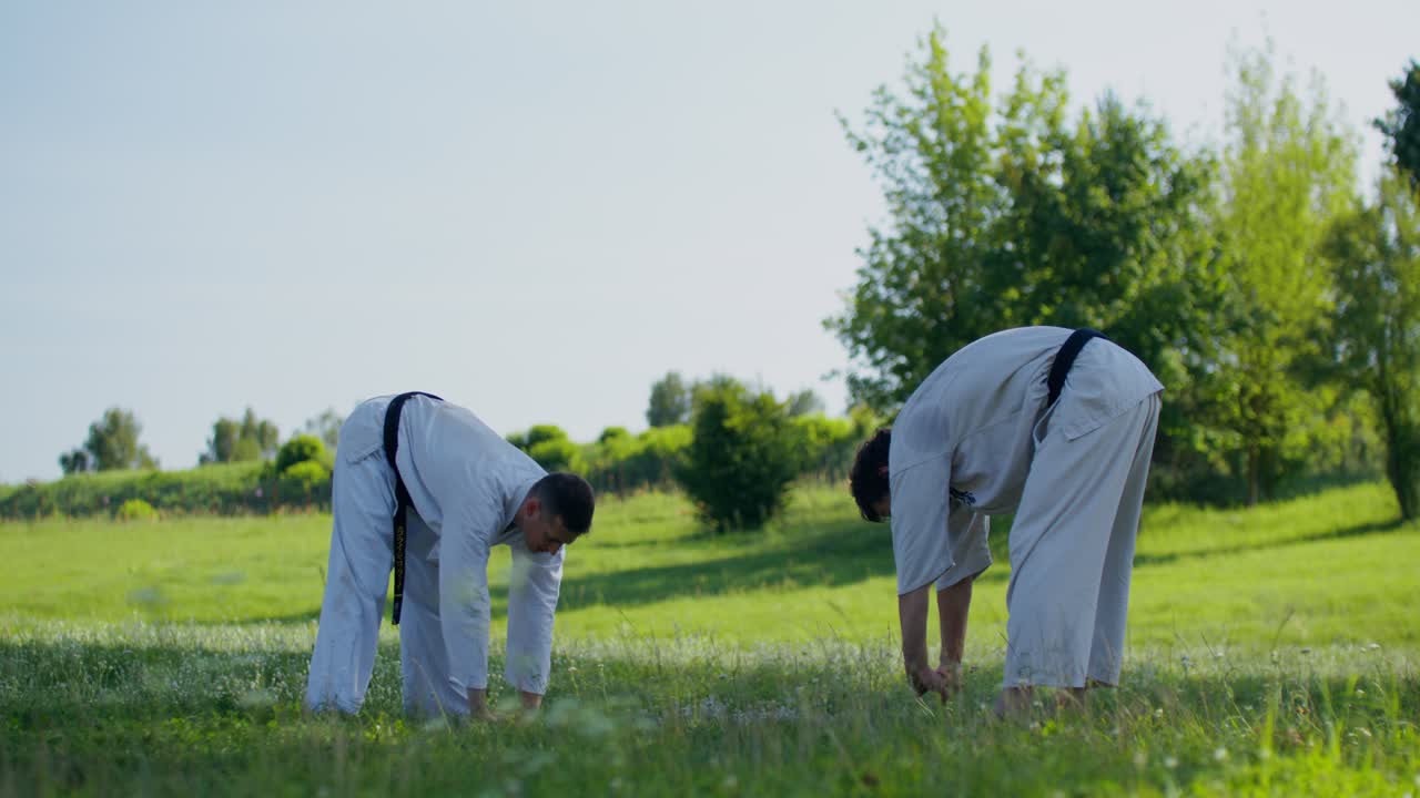 Dua pria berlatih karate di luar ruangan